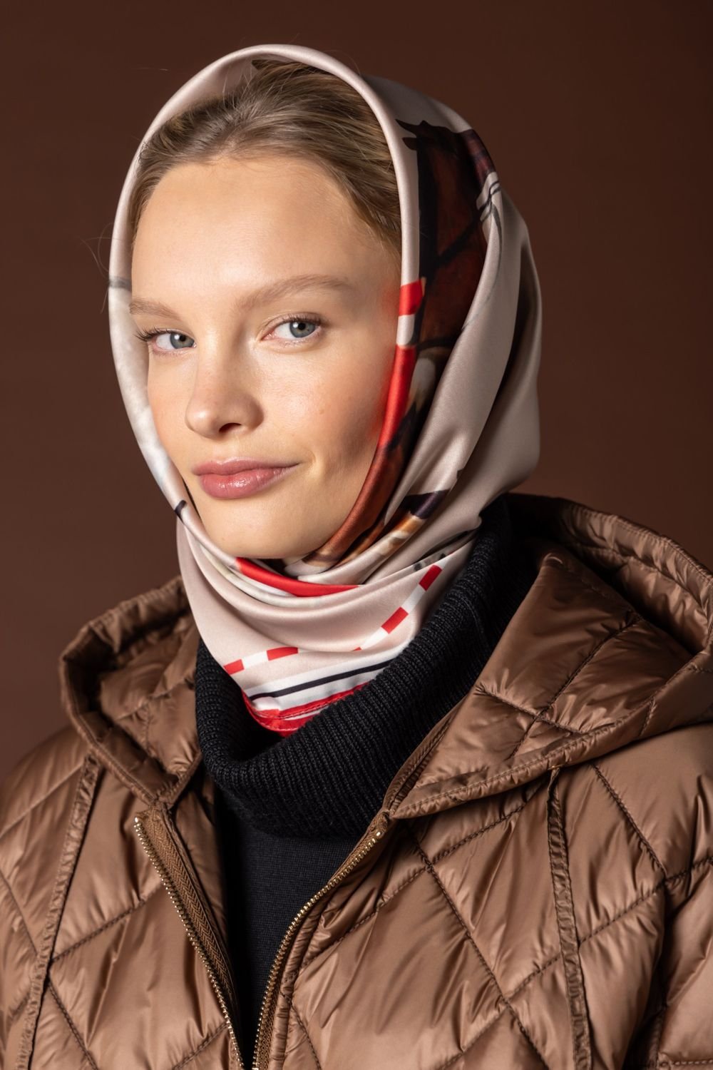 Scarf worn as a headscarf over a quilted jacket